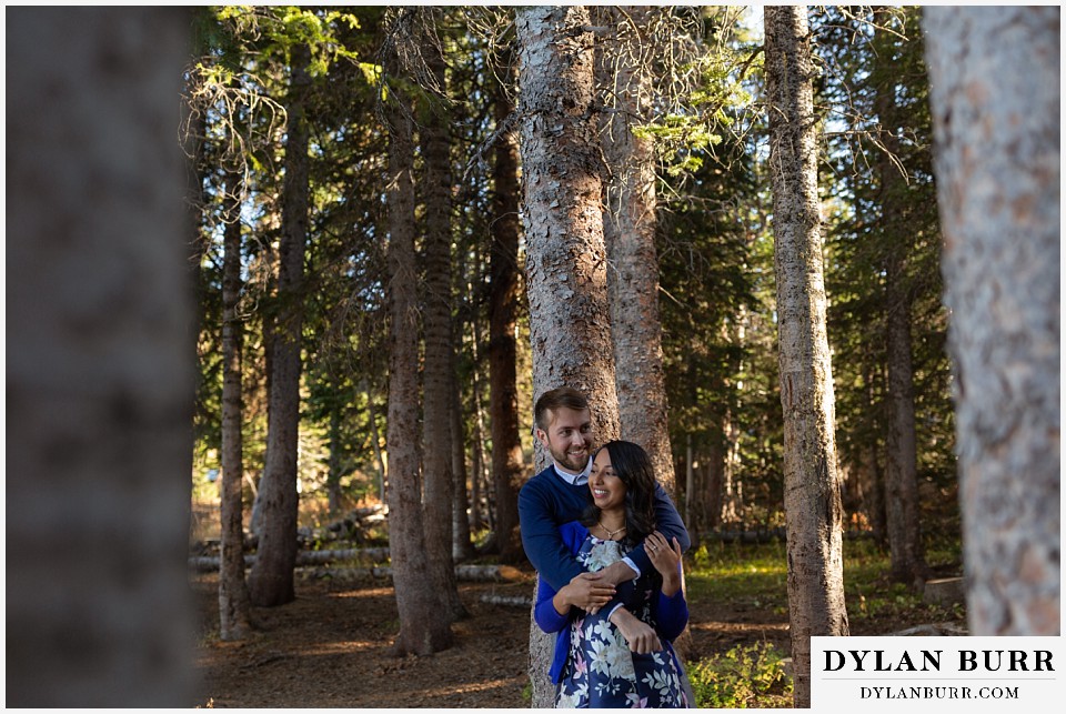 colorado engagement photos in mountains couple hugging in trees