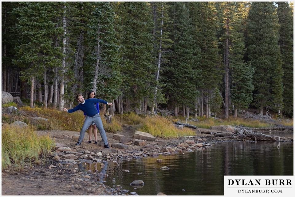 colorado engagement photos in mountains throwing stones in lake