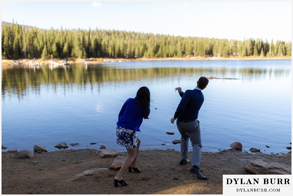 colorado engagement photos in mountains couple skipping stones in lake