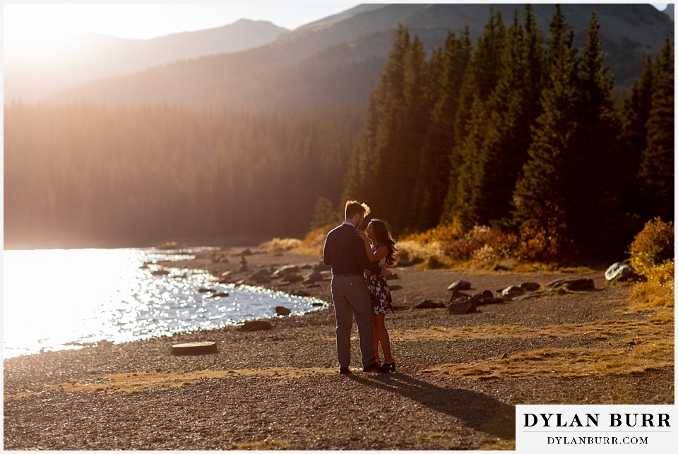 colorado engagement photos in mountains couple dancing together by lake