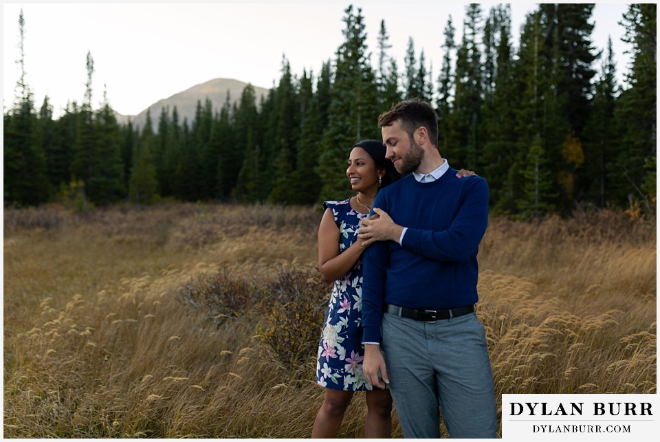 colorado engagement photos in mountains couple standing together in tall grass
