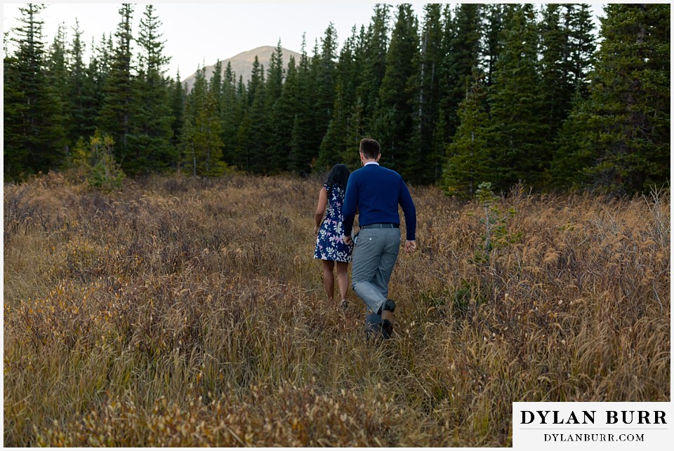 colorado engagement photos in mountains couple running in field