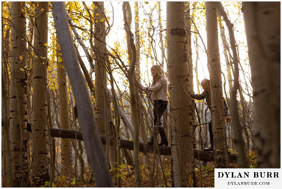 colorado engagement session in mountains walking on fallen tree