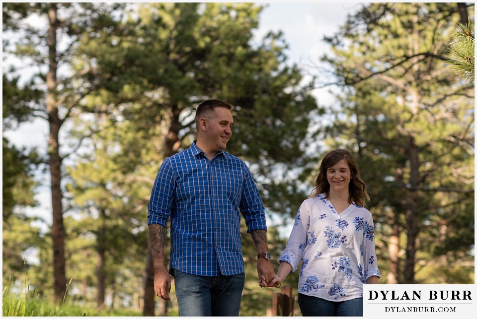 golden colorado mountain enagagement photo session couple walking together in forest