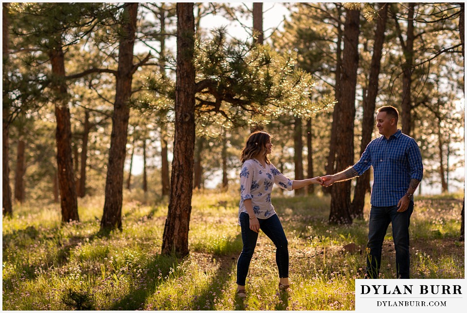 golden colorado mountain enagagement photo session couple dancing in swinging her out