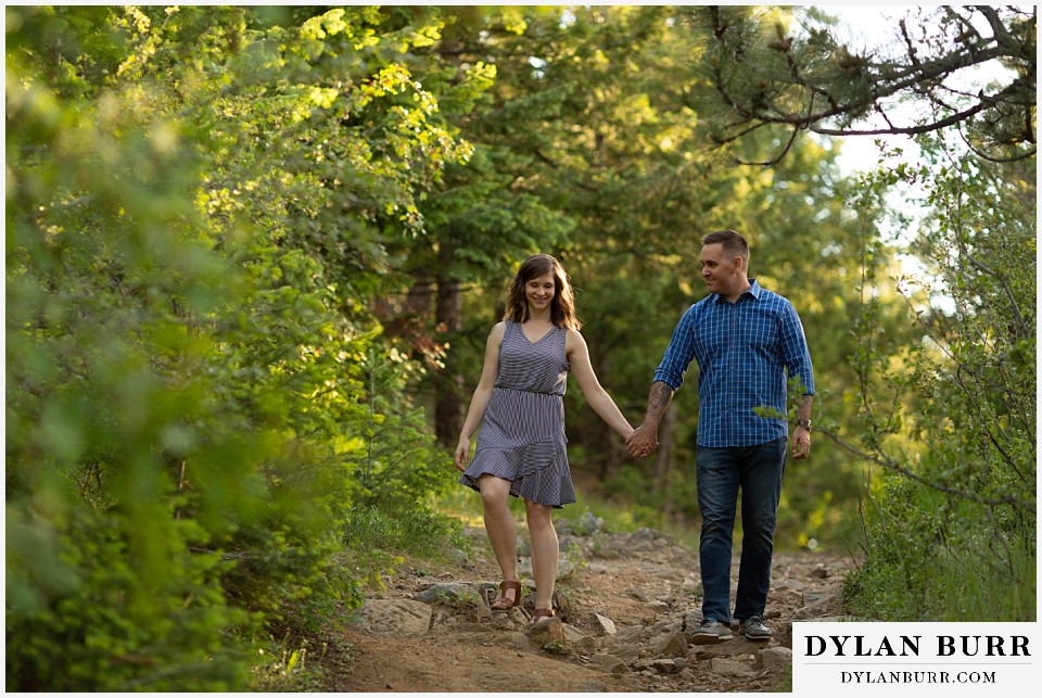 golden colorado mountain enagagement photo session couple laughing while walking on trail