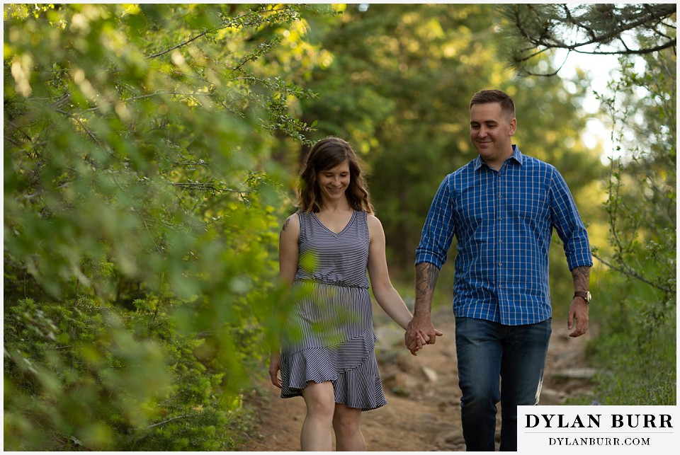 golden colorado mountain enagagement photo session couple trying to focus on the rough trail