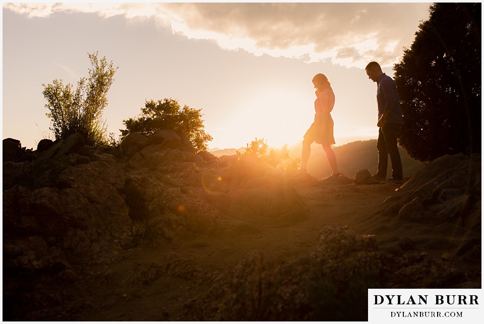 golden colorado mountain enagagement photo session couple walking through the sunlight glow