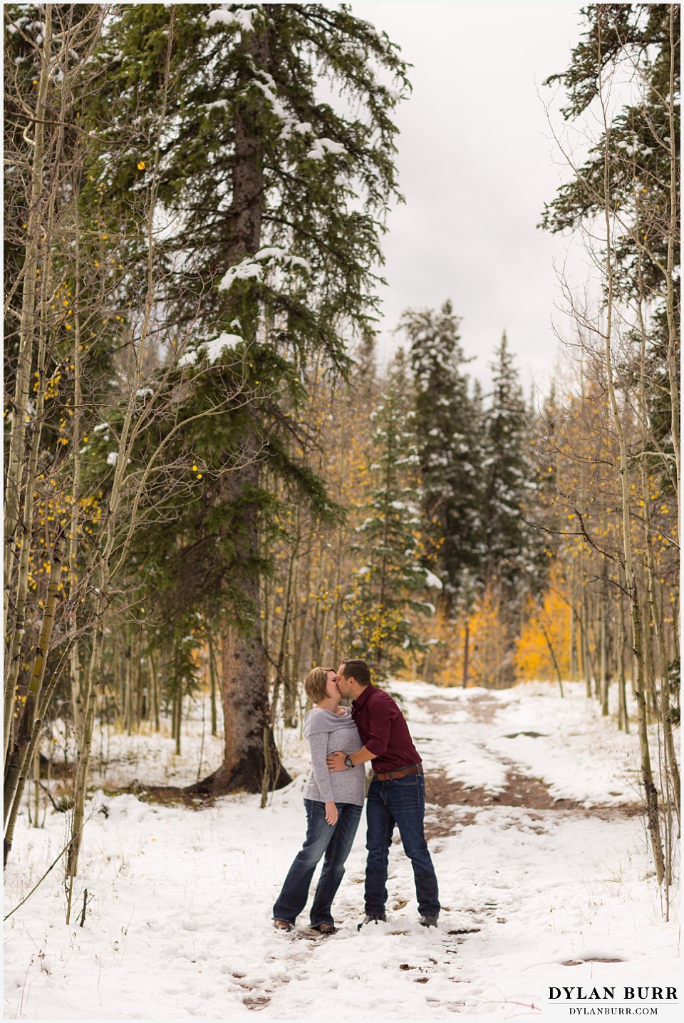 colorado mountain engagement session sharing a kiss in the fall snow