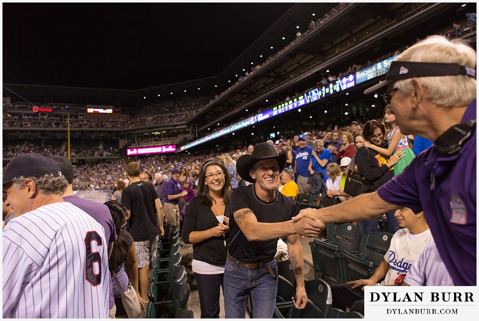 proposal at coors field rockies game shaking hands with event staff