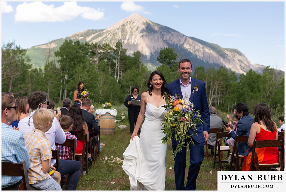 newlywed couple leaving ceremony at crested butte land trust