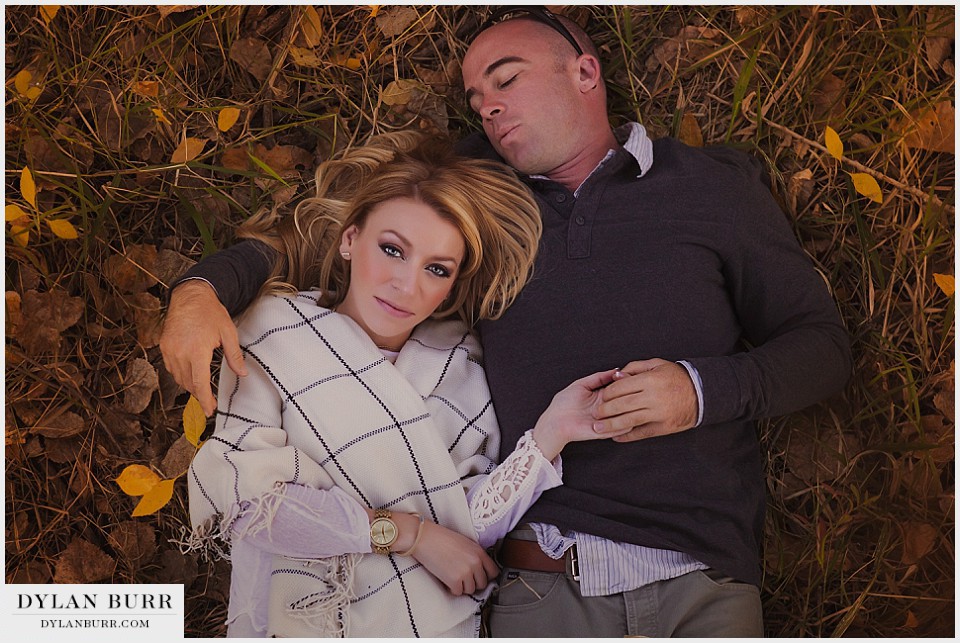 denver engagement photographer fall colors laying down in the leaves on the ground