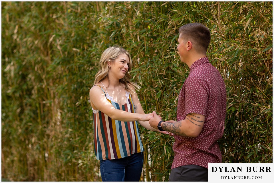 denver engagement photos dairy block downtown denver holding hands near a bamboo wall
