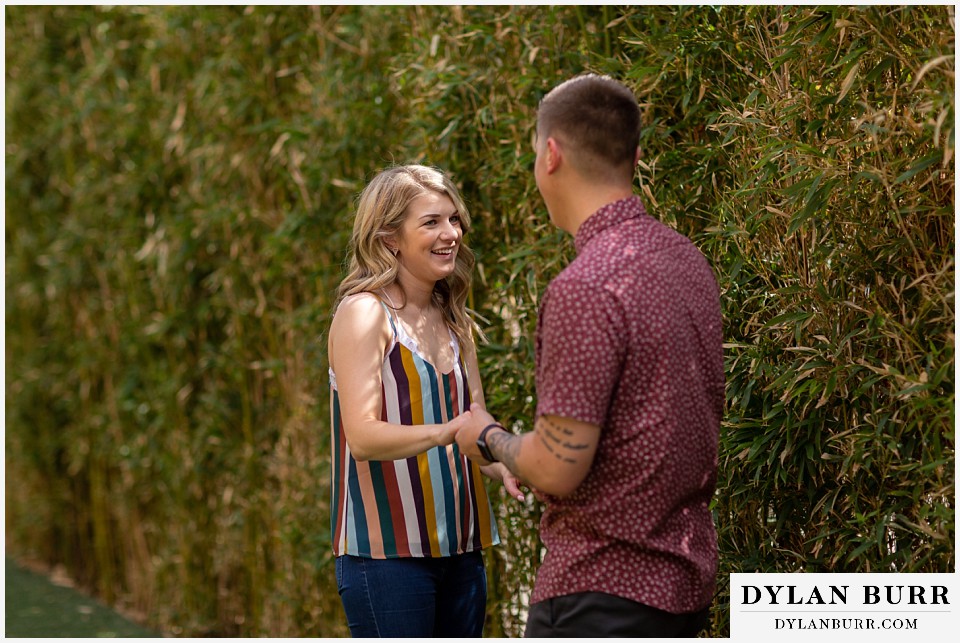 denver engagement photos dairy block downtown denver shes laughing and holding his hands