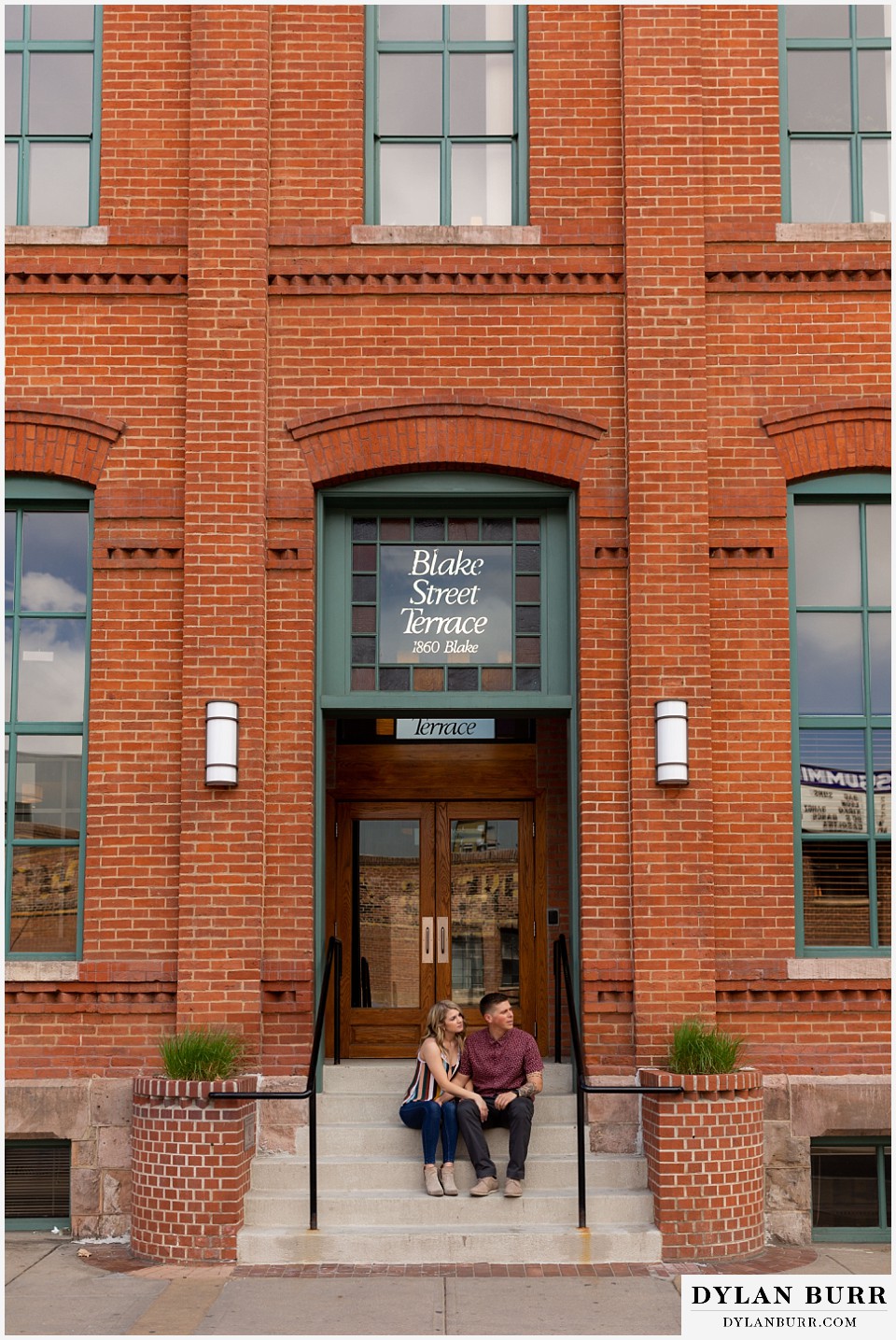 denver engagement photos dairy block downtown denver sitting together on Blake Street