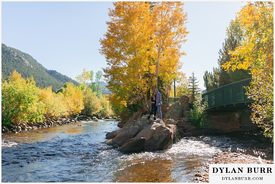 downtown estes park engagement photos relaxing at a fork in the river