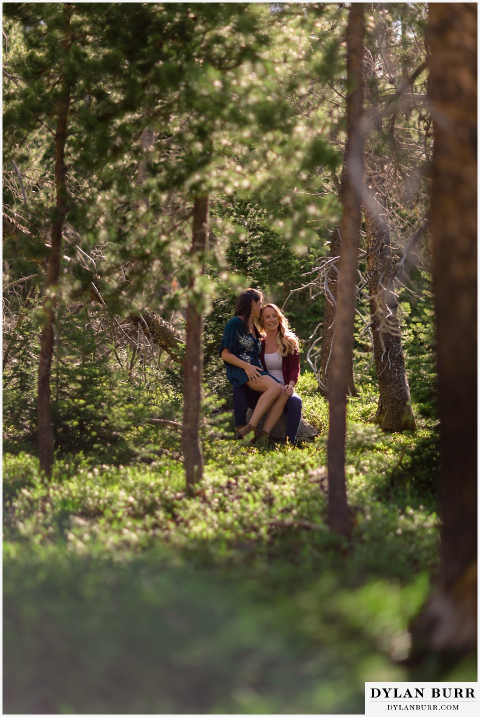 estes park engagement photos taking a minute together on a rock in the forest