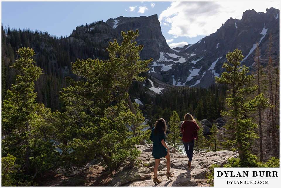 estes park engagement photos couple climbing in mountains in heels
