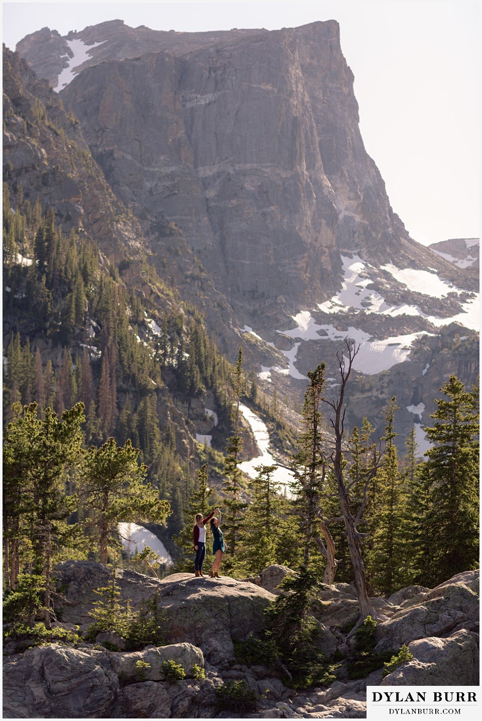 estes park engagement photos dancing together on top of rocks