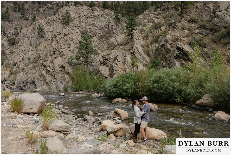 newly engaged couple near mountain river