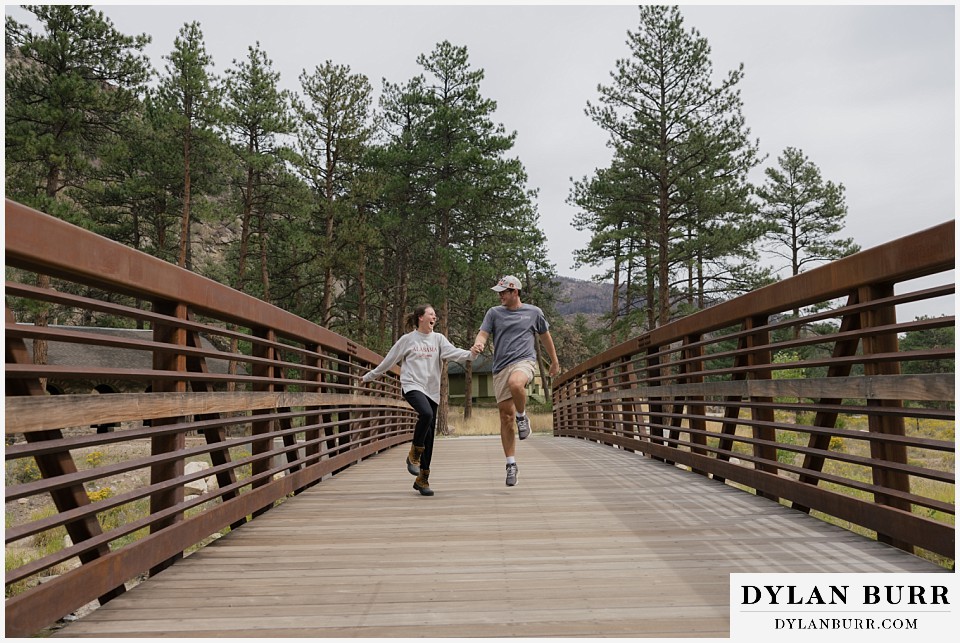 estes park marriage proposal playing together on a bridge