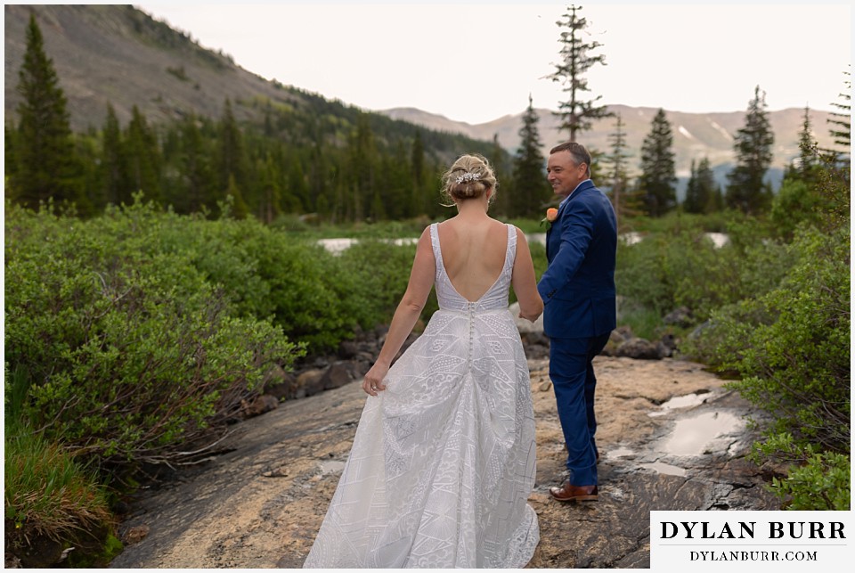 groom leads bride into the forest elopement wedding