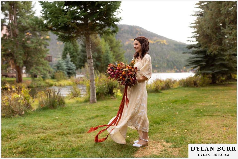 grand lake wedding elopement bride standing alone near lake shore