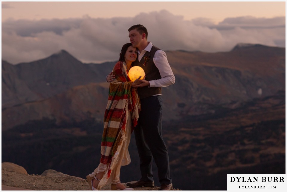 rocky mountain national park grand lake wedding elopement bride and groom on mountaintop holding moon harvest moon at twilight