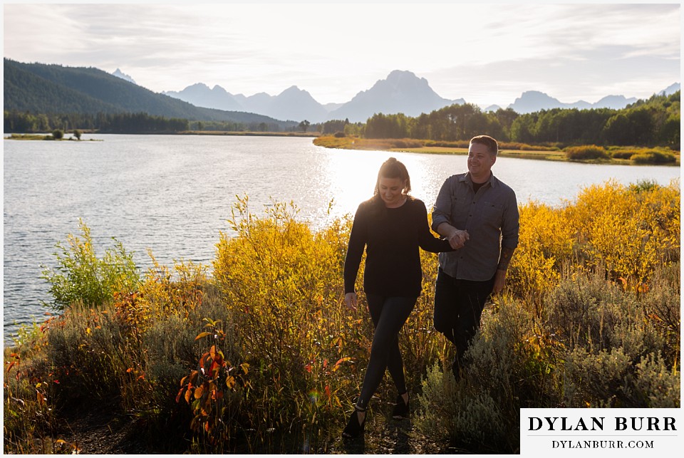 grand teton wedding anniversary photos couple holding hands while walking by river