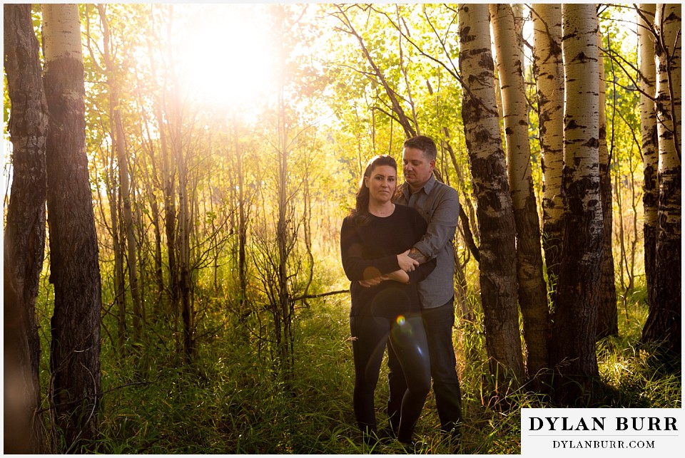 grand teton wedding anniversary photos couple standing together in aspen trees with a bit of light flare