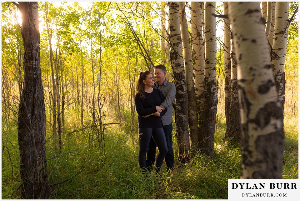 grand teton wedding anniversary photos couple standing in tall grass in forest