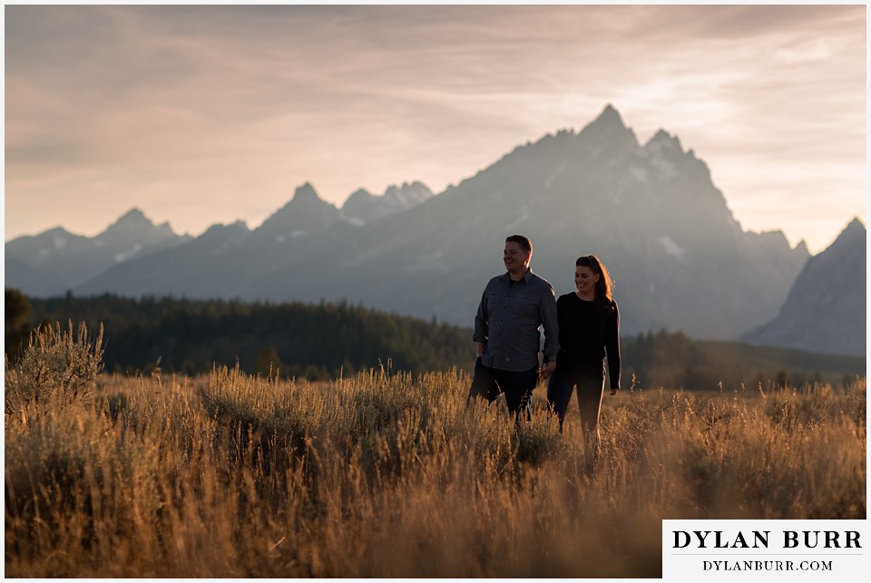 grand teton wedding anniversary photos couple walking together through tall grass