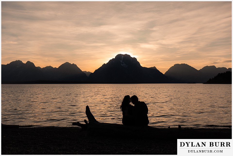 grand teton wedding anniversary photos relaxing on a log at Jackson Lake