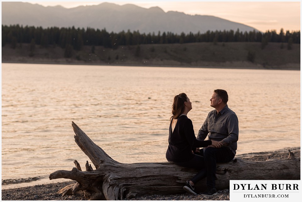 grand teton wedding anniversary photos couple together on giant log looking at the sunset