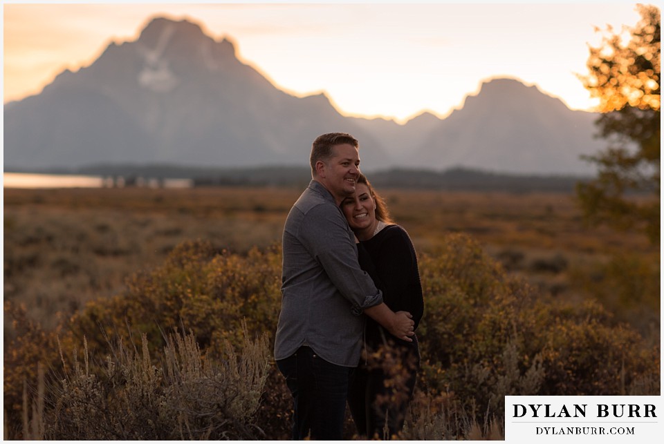 grand teton wedding anniversary photos laughing together in large fall foliage field