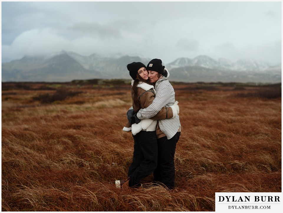 lgtbq couples hot springs session in Iceland a great close hug with mountains in the background