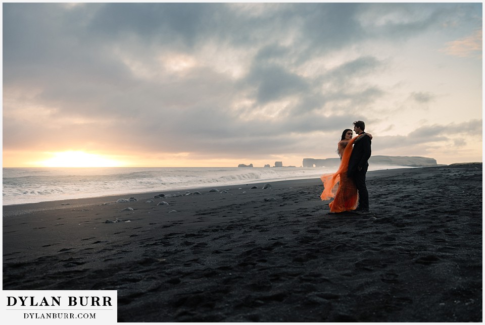 iceland elopement at reynisfjara beach orange dress on black sand beach