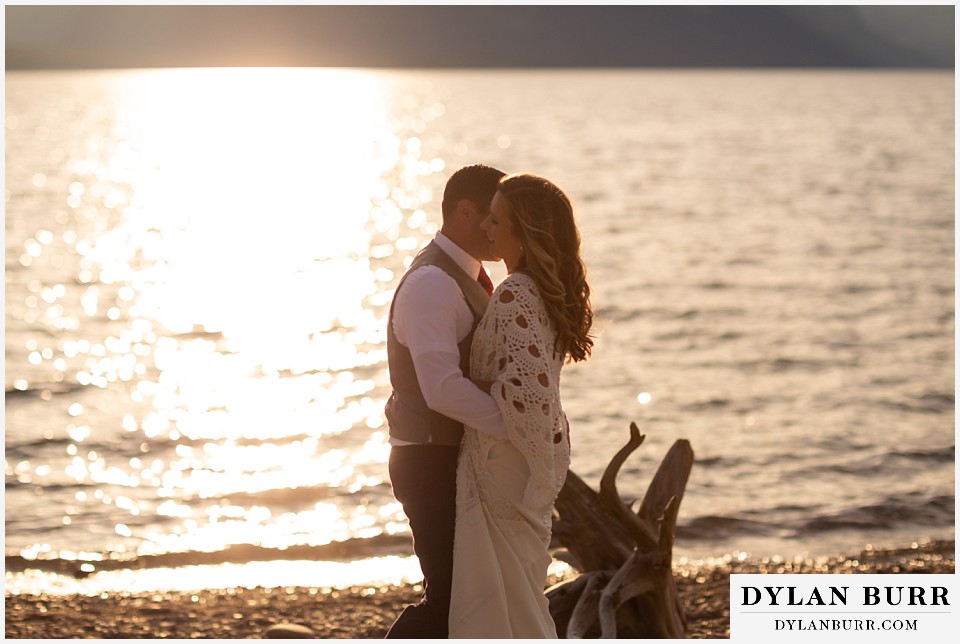 jackson lake lodge wedding grand tetons wyoming groom getting in close with bride at lake sunset