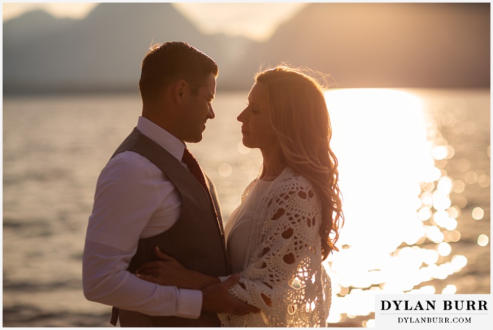 jackson lake lodge wedding grand tetons wyoming bride and groom taking a minute in the sunlight by the lake