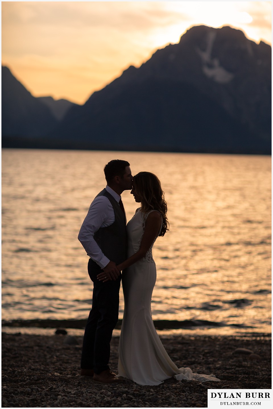 jackson lake lodge wedding grand tetons wyoming groom kissing brides forhead silhouette at sunset