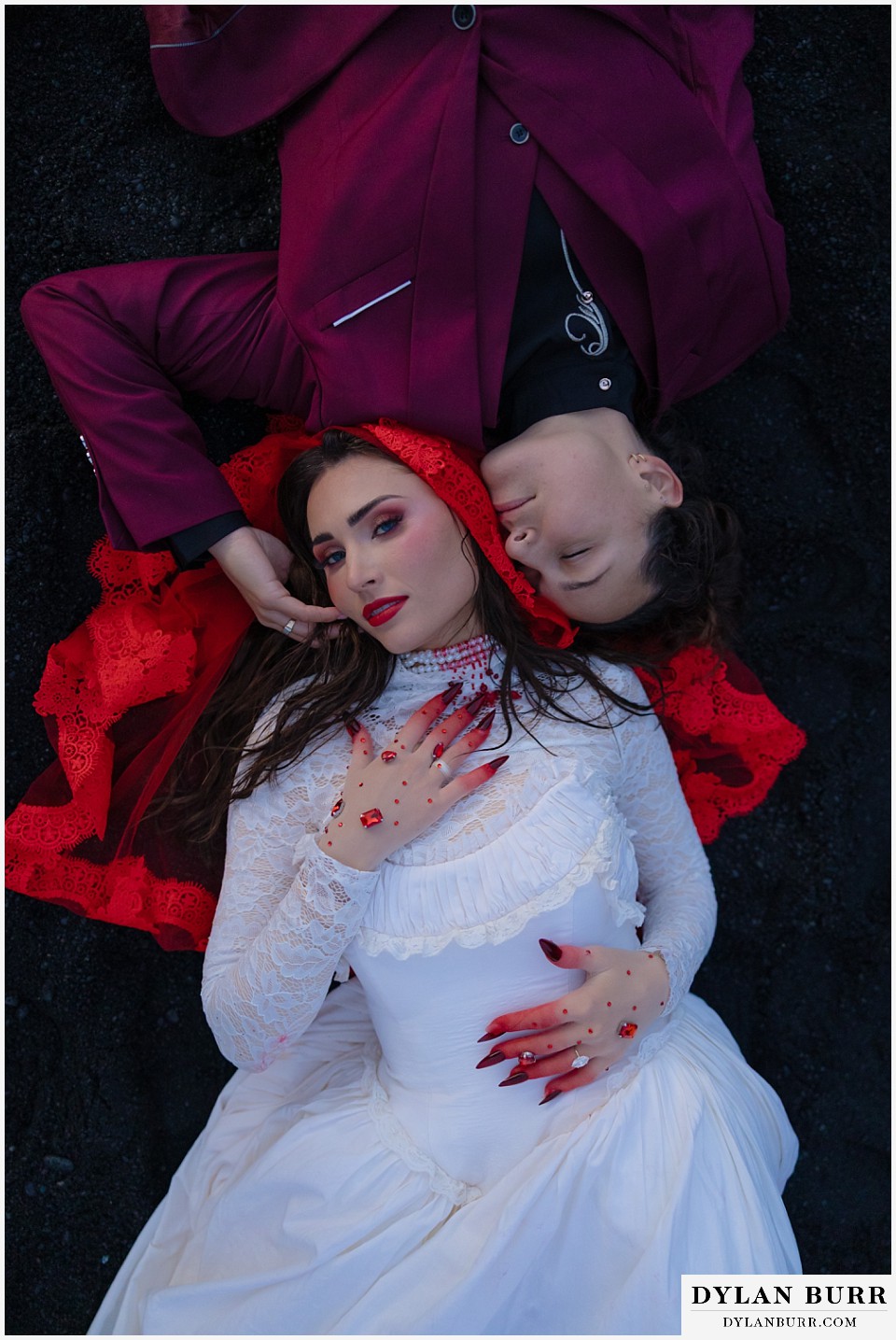 lgtbq iceland elopement wedding Reynisfjara Beach laying on black sand beach with red veil
