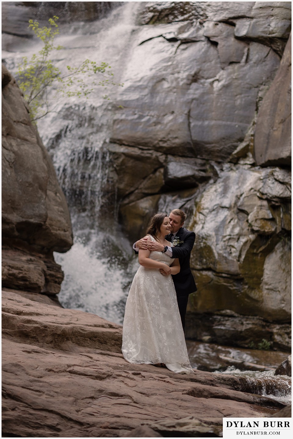 marble colorado elopement wedding newlyweds kissing near waterfall in mountains