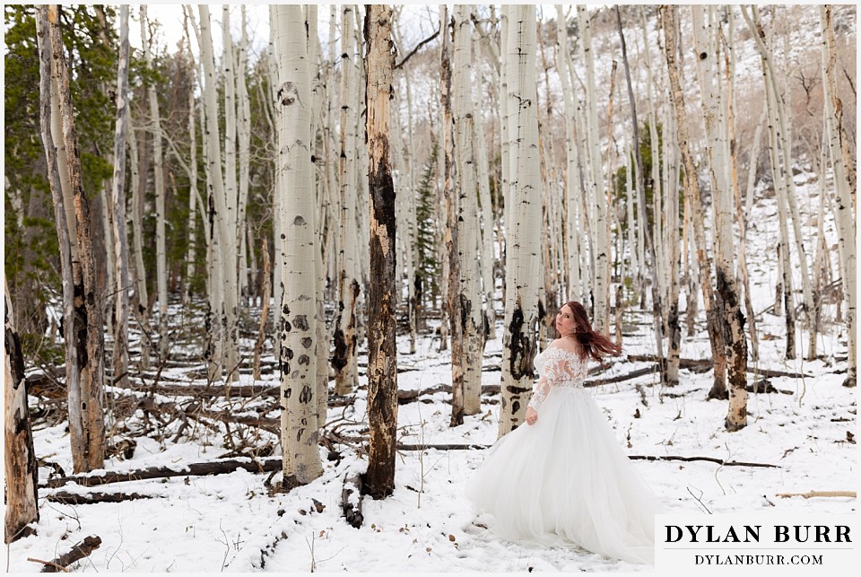bride spinning dress alone in the trees on her mountain wedding day