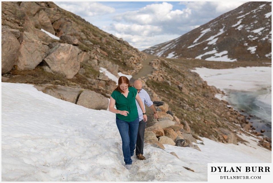 couple hiking in snow on mountain top