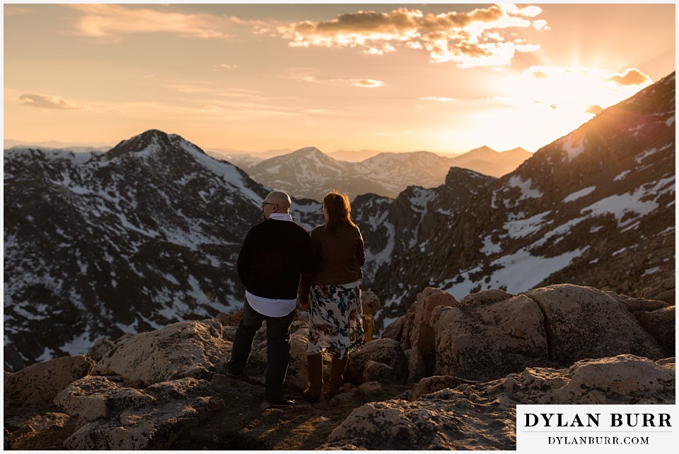 couple during engagement session looking out at sunset