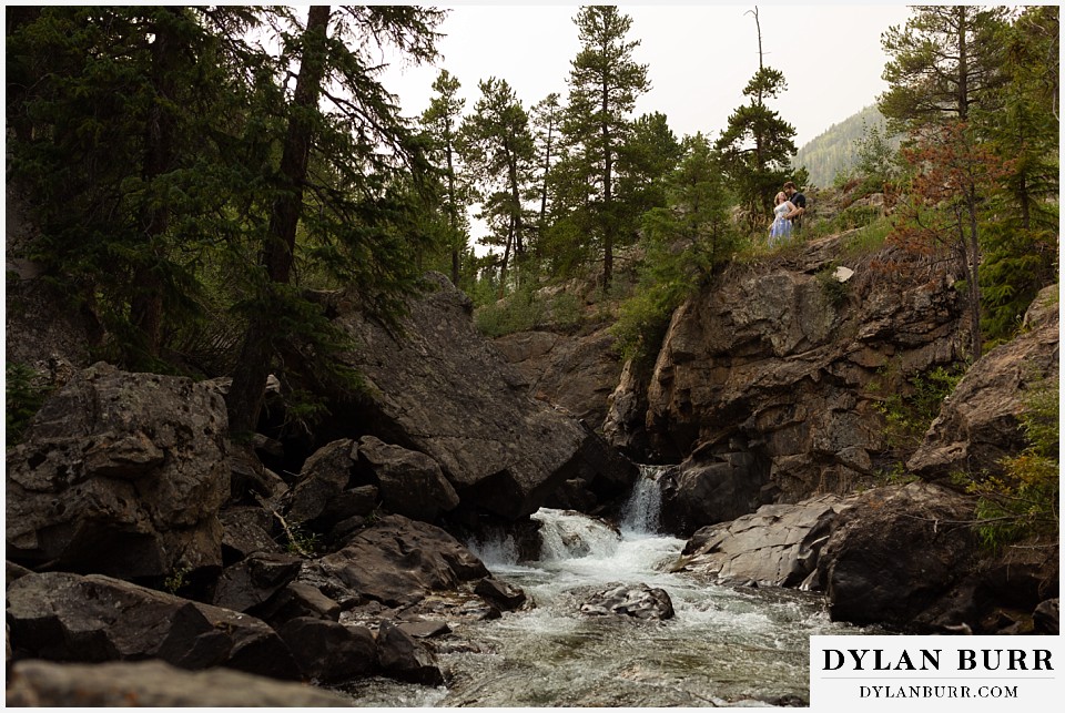 mountain adventure elopement wedding colorado small river waterfall with newlyweds above