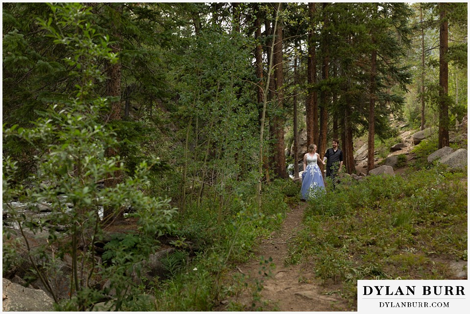 mountain adventure elopement wedding colorado bride and groom walking along forest trail
