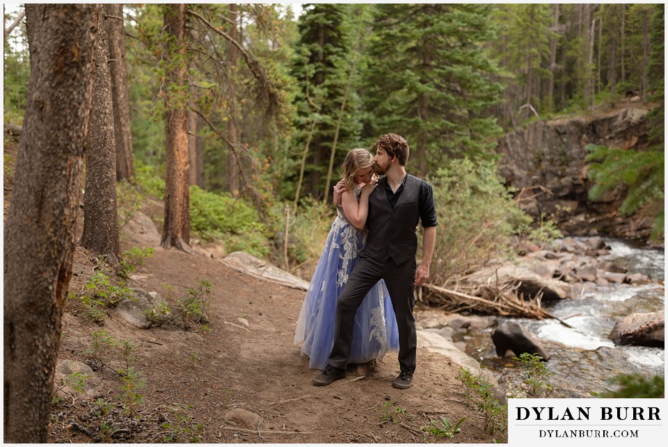 mountain adventure elopement wedding colorado groom whispering to bride behind him