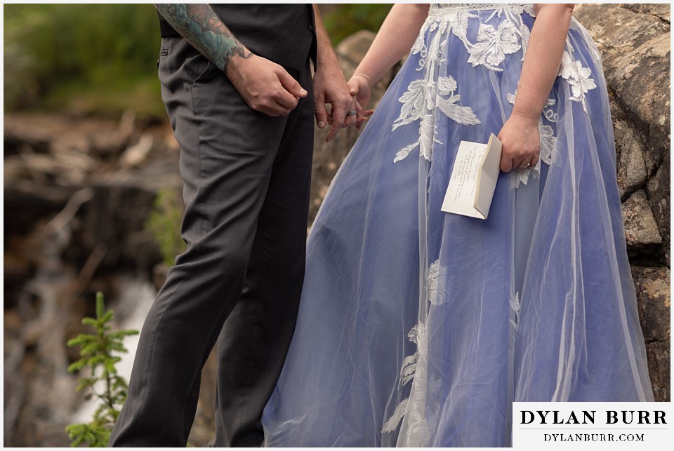 mountain adventure elopement wedding colorado bride holds her written vows by her side