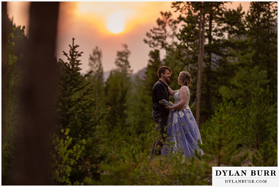 mountain adventure elopement wedding colorado bride and groom dancing in mountain with wildfires in background